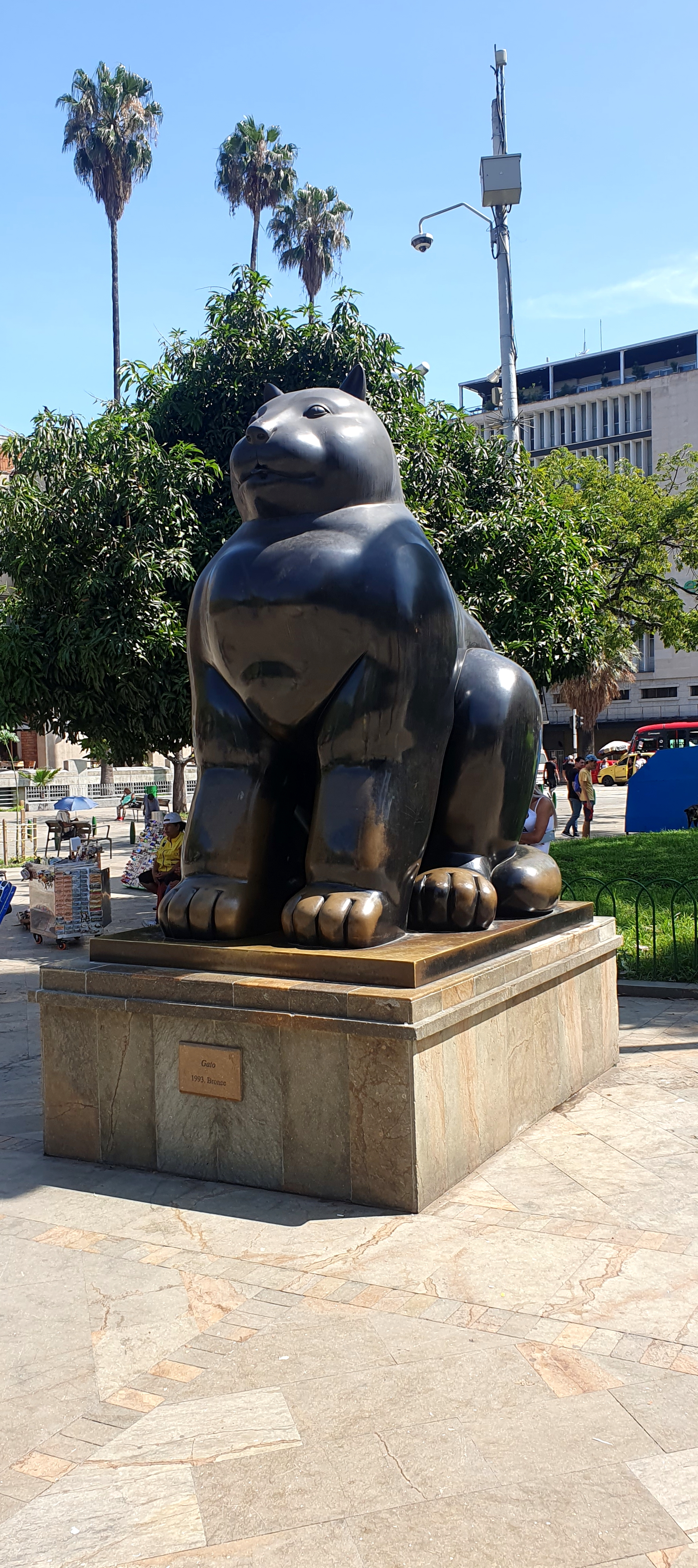 Plaza Botero in Medellín, Colombia, with Fernando Botero's monumental bronze sculptures in the foreground and the city skyline behind