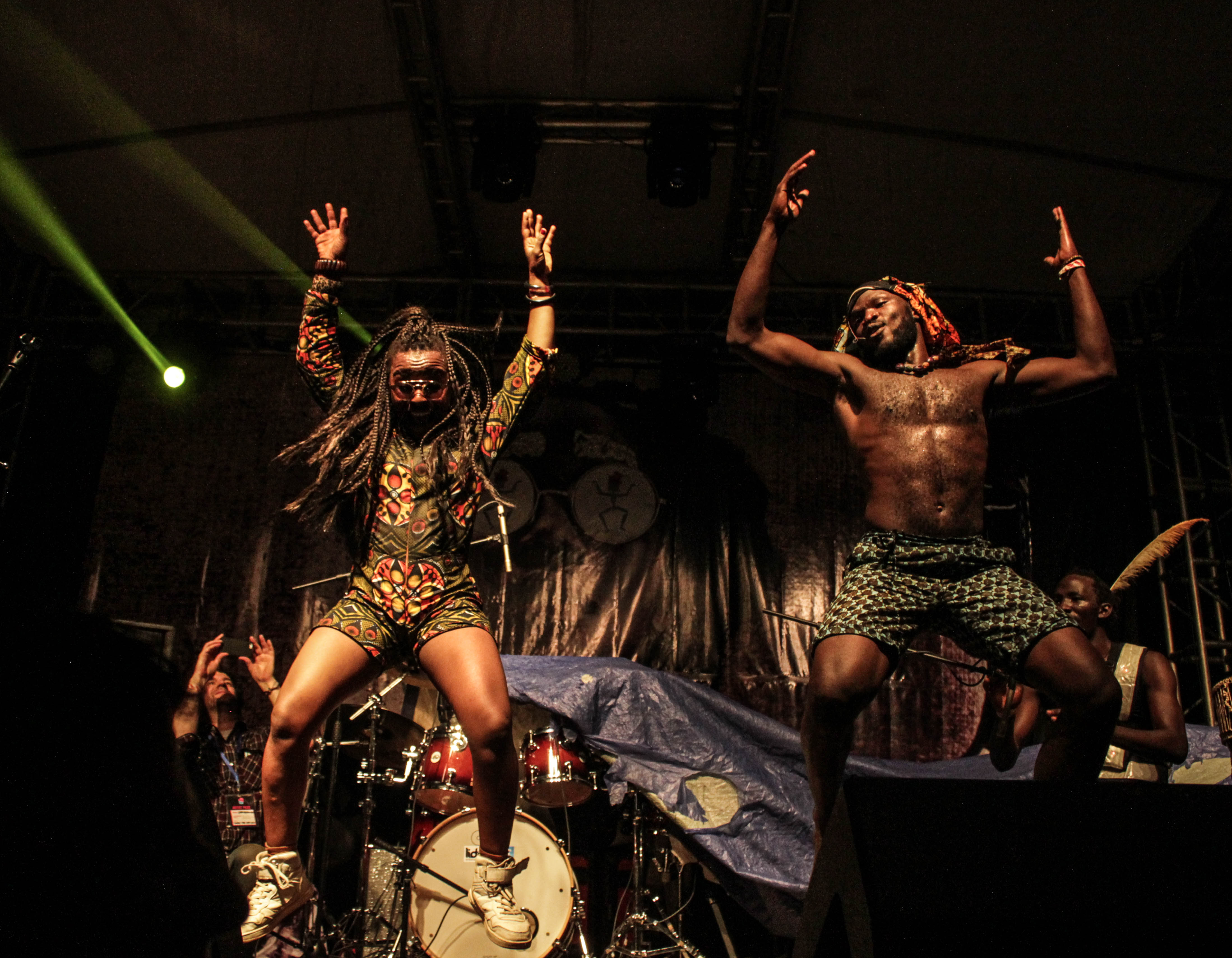 Festival crowd dancing at night on the green riverbank stages of Nyege Nyege with the Nile visible in the background at Jinja Uganda